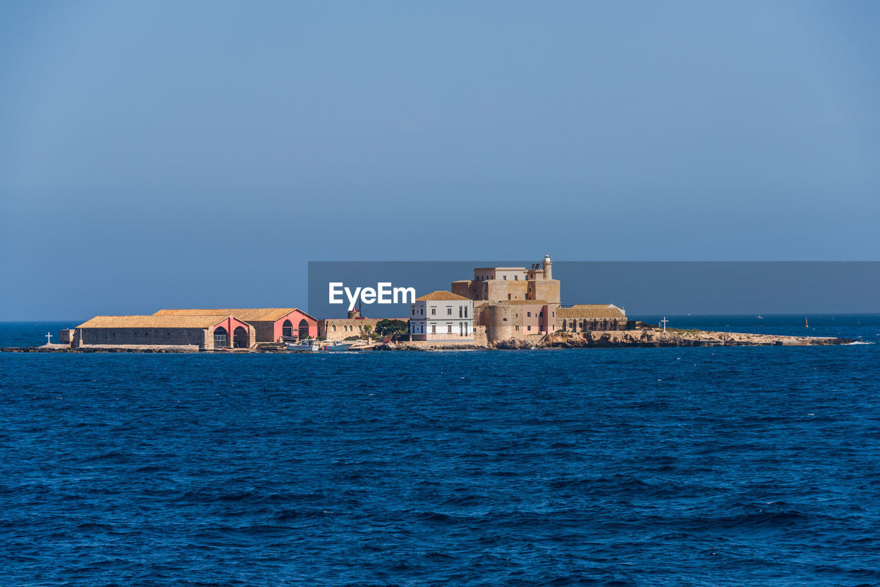 View of sea and buildings against sky