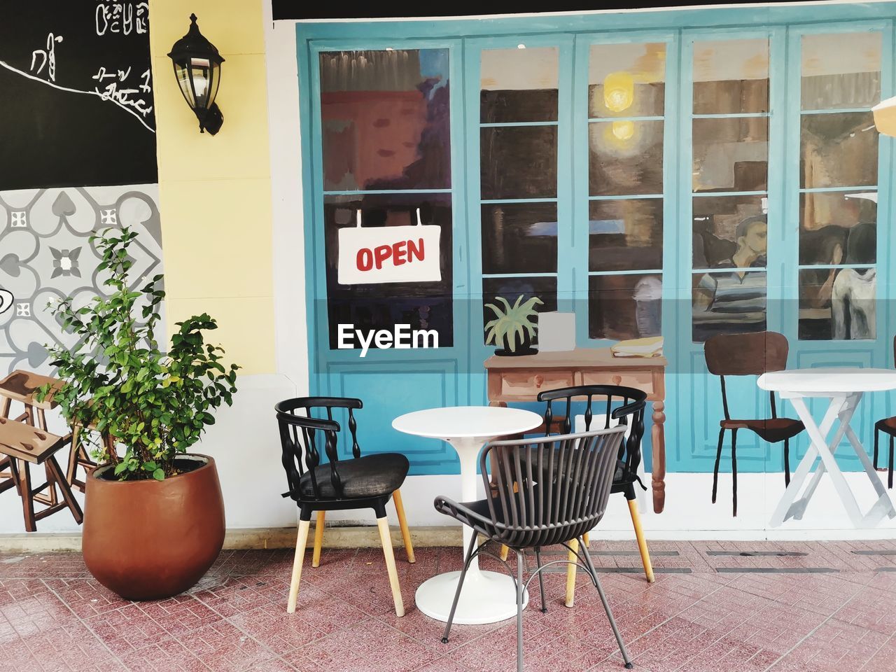 EMPTY CHAIRS AND TABLES IN CAFE