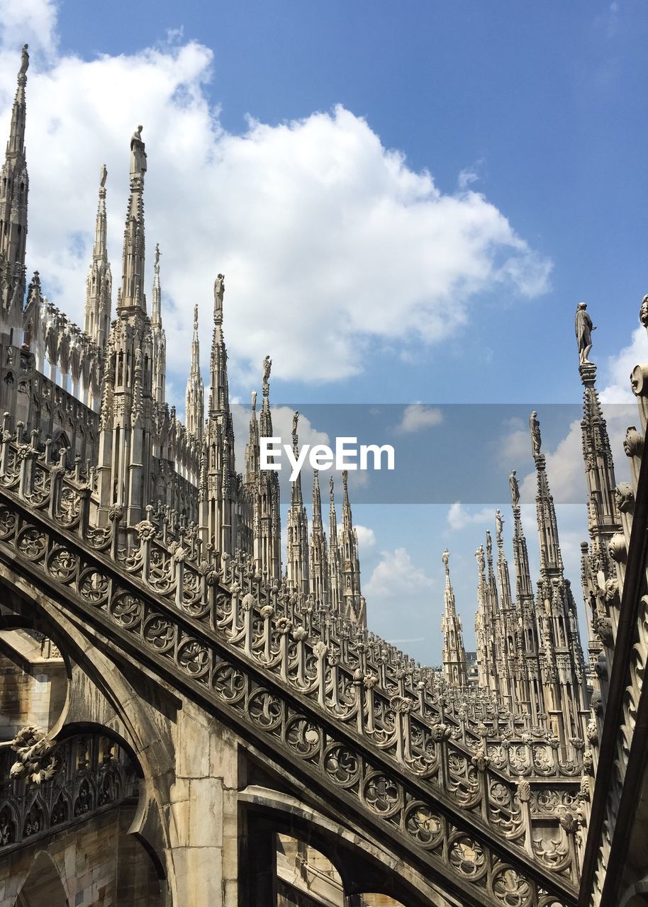 Low angle view of milan cathedral against cloudy sky