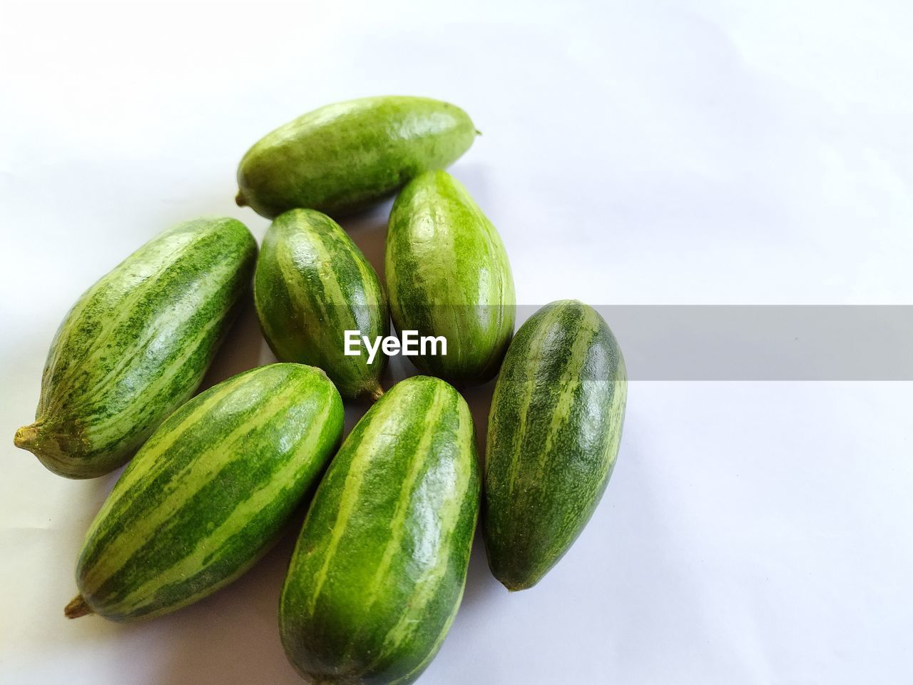 HIGH ANGLE VIEW OF GREEN CHILI PEPPERS AGAINST WHITE BACKGROUND