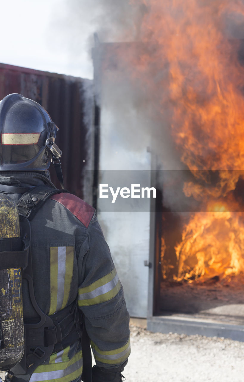 Rear view of firefighter working outdoors