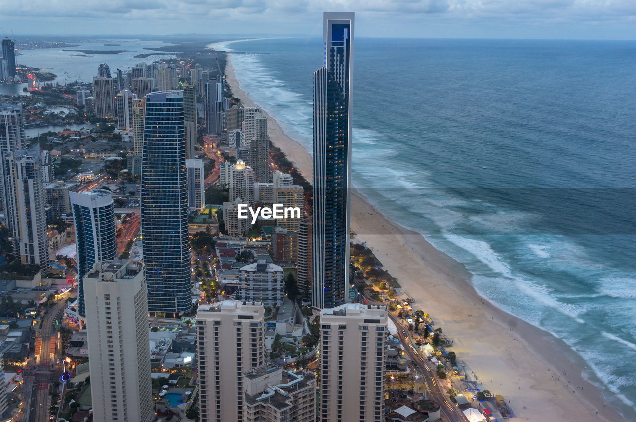 Aerial cityscape of modern city with skysrapers and tall office buildings along the ocean coastline