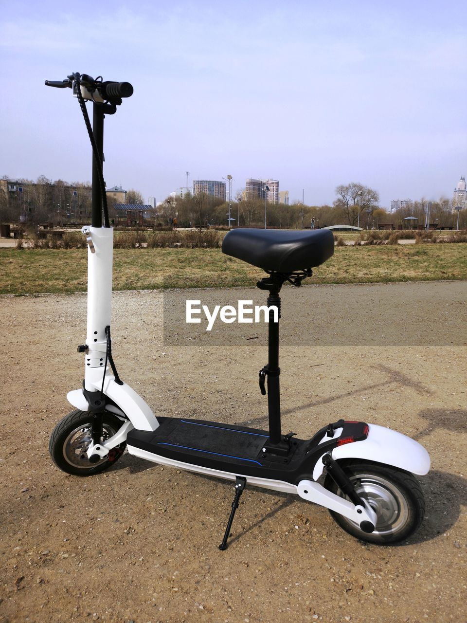 BICYCLE PARKED ON FIELD AGAINST SKY