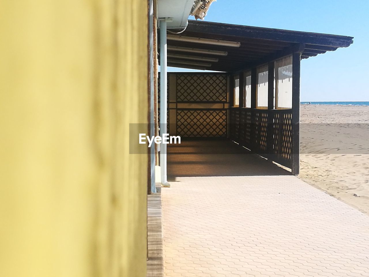 Corridor of building by sea against sky, bar on the beach 