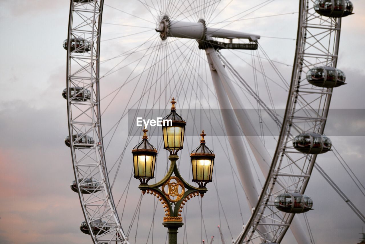 Low angle view of street light against millennium wheel