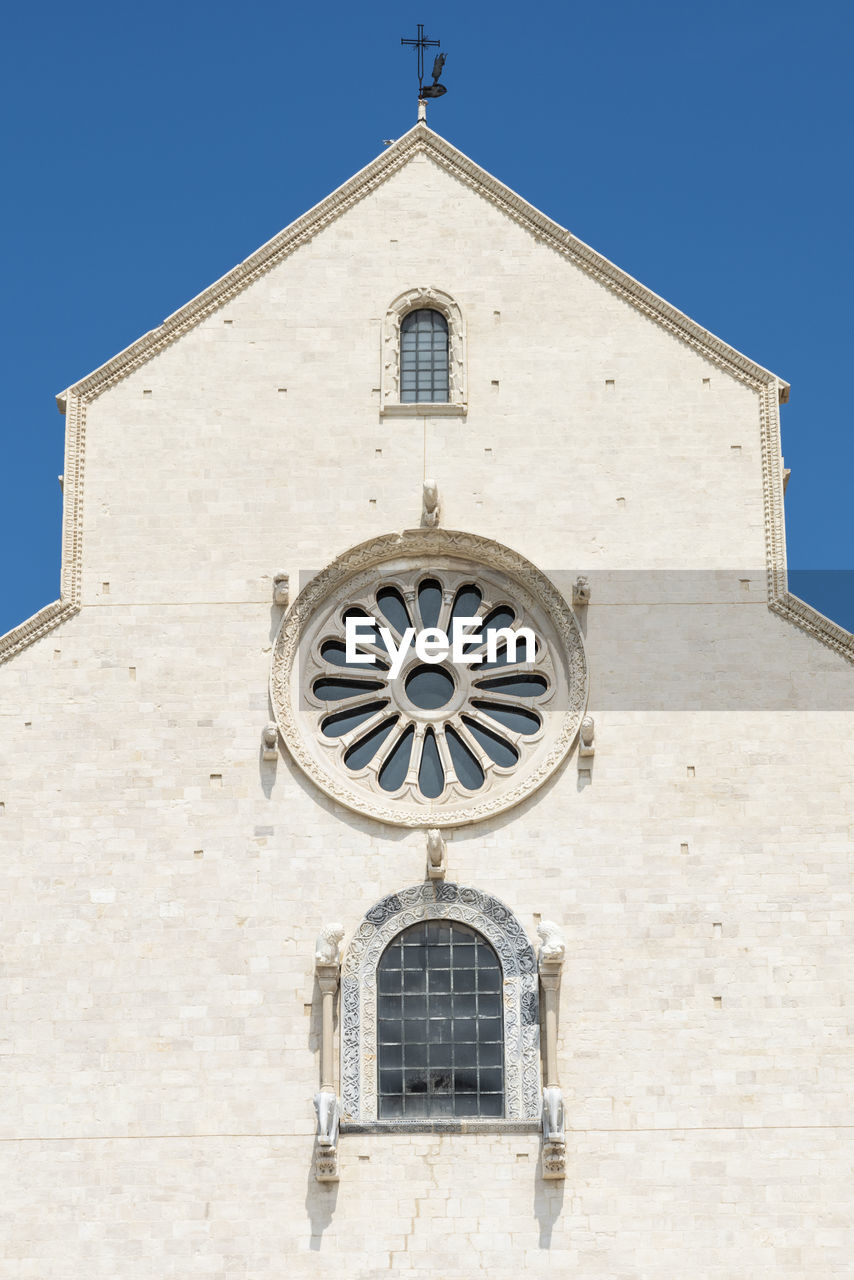 LOW ANGLE VIEW OF CROSS AGAINST BUILDING