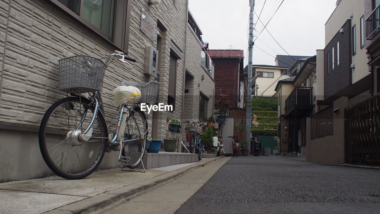 BICYCLE PARKED ON STREET BY BUILDINGS