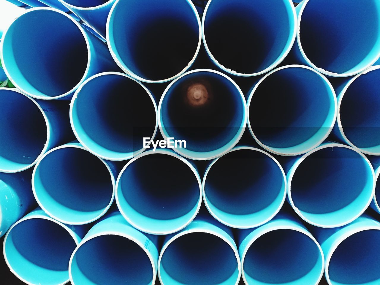 FULL FRAME SHOT OF STACK OF BLUE PIPES