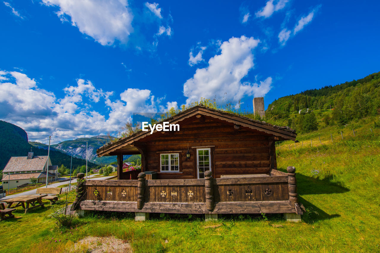 BUILDING ON FIELD AGAINST SKY