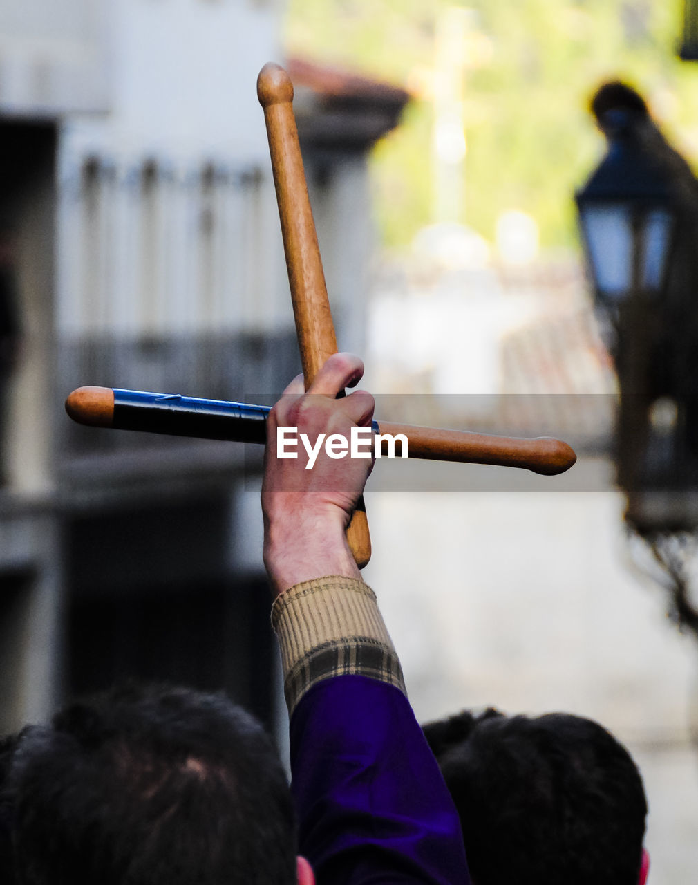 Cropped hand raised with wooden sticks during holy week