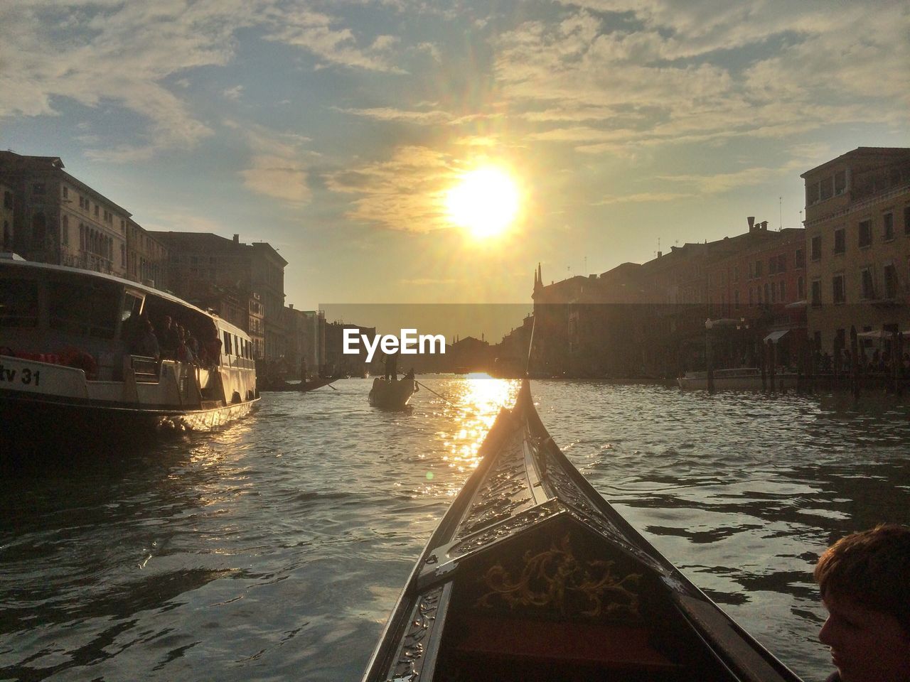 Boats sailing in canal during sunset