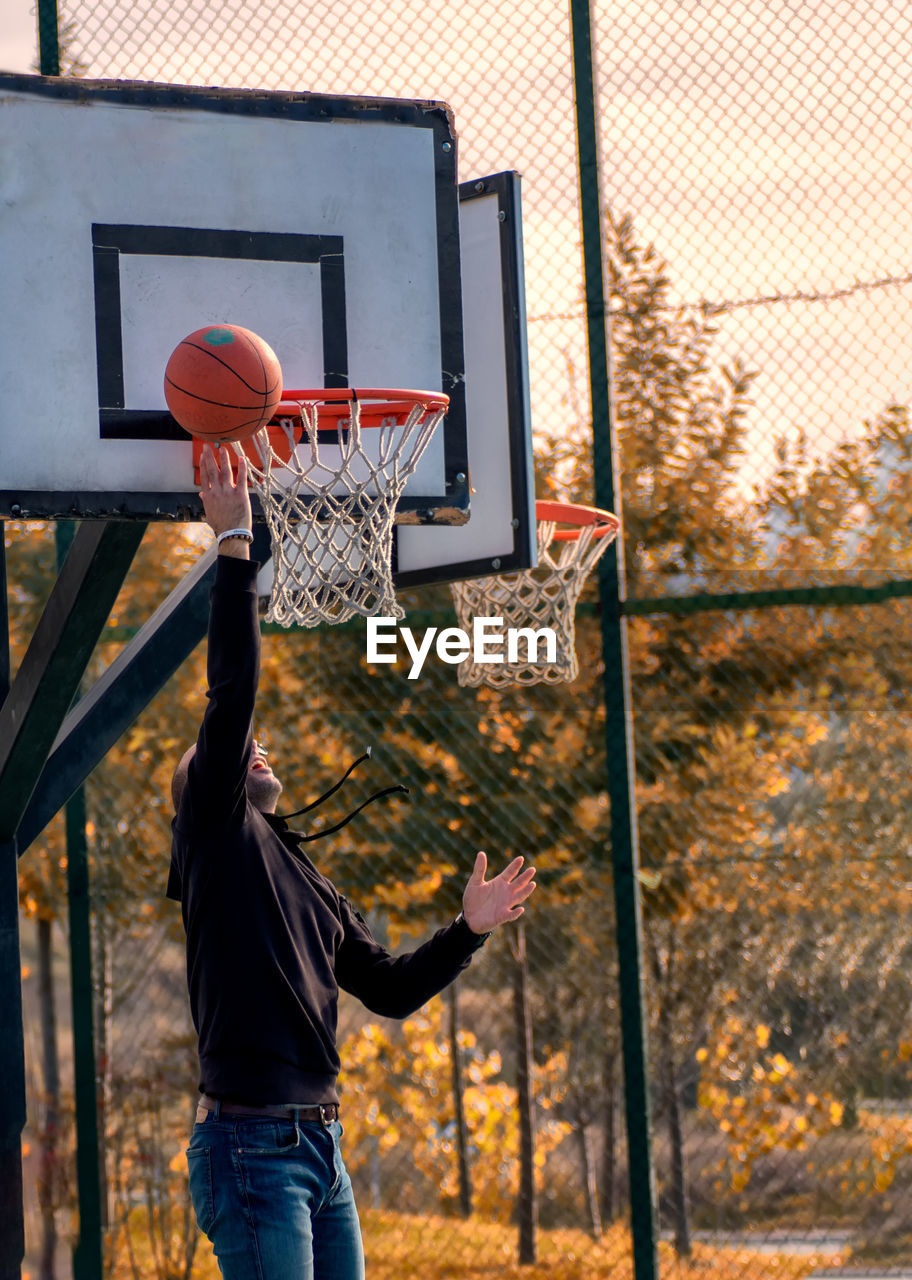 Man playing with basketball hoop