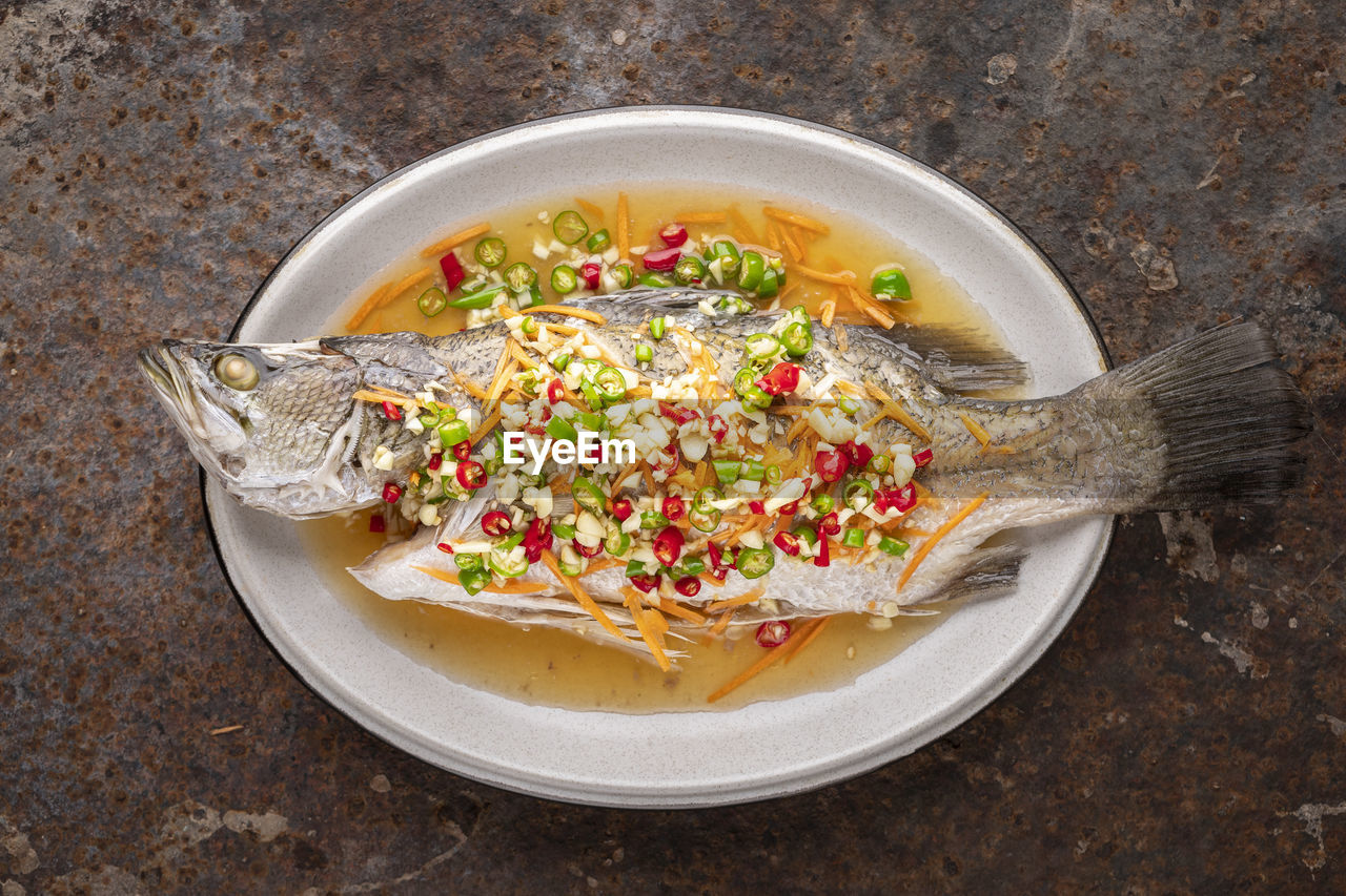 Steamed sea bass fish with lemon, garlic, chili, carrot, seabass, giant sea perch, barramundi, barra