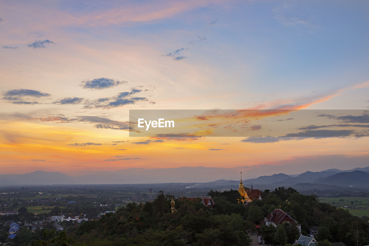 HIGH ANGLE VIEW OF BUILDINGS AGAINST CLOUDY SKY