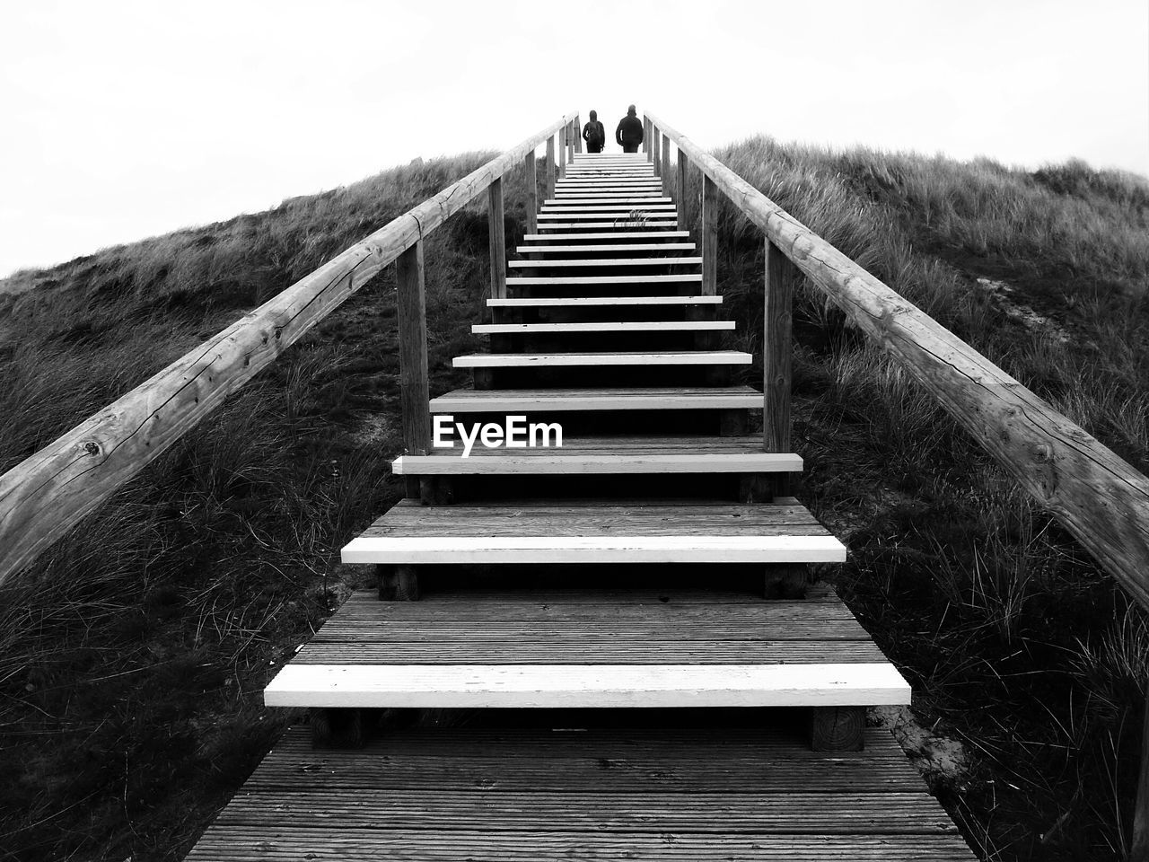 Low angle view of people on steps against sky