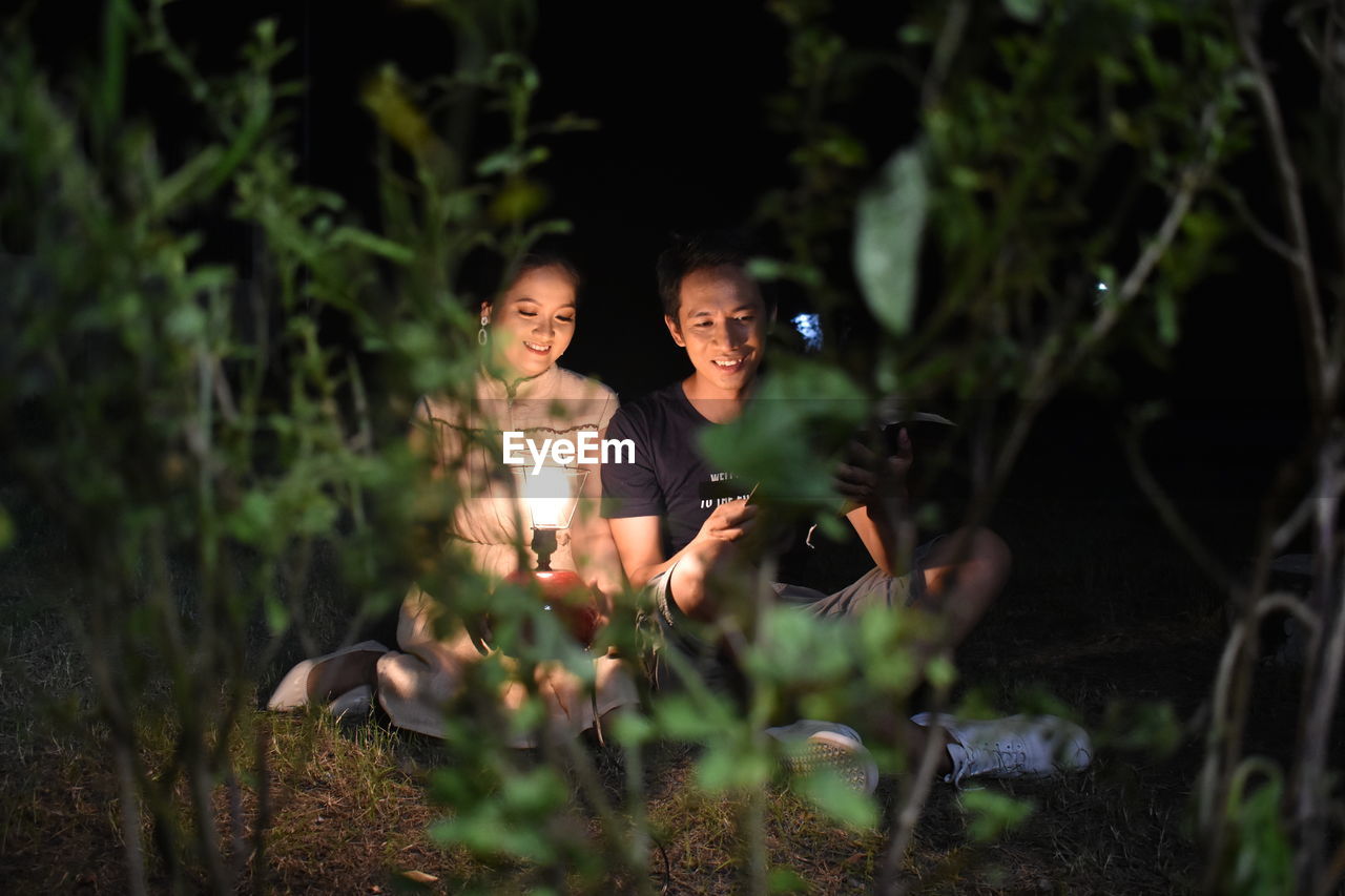 Full length of woman and man on land camping outside