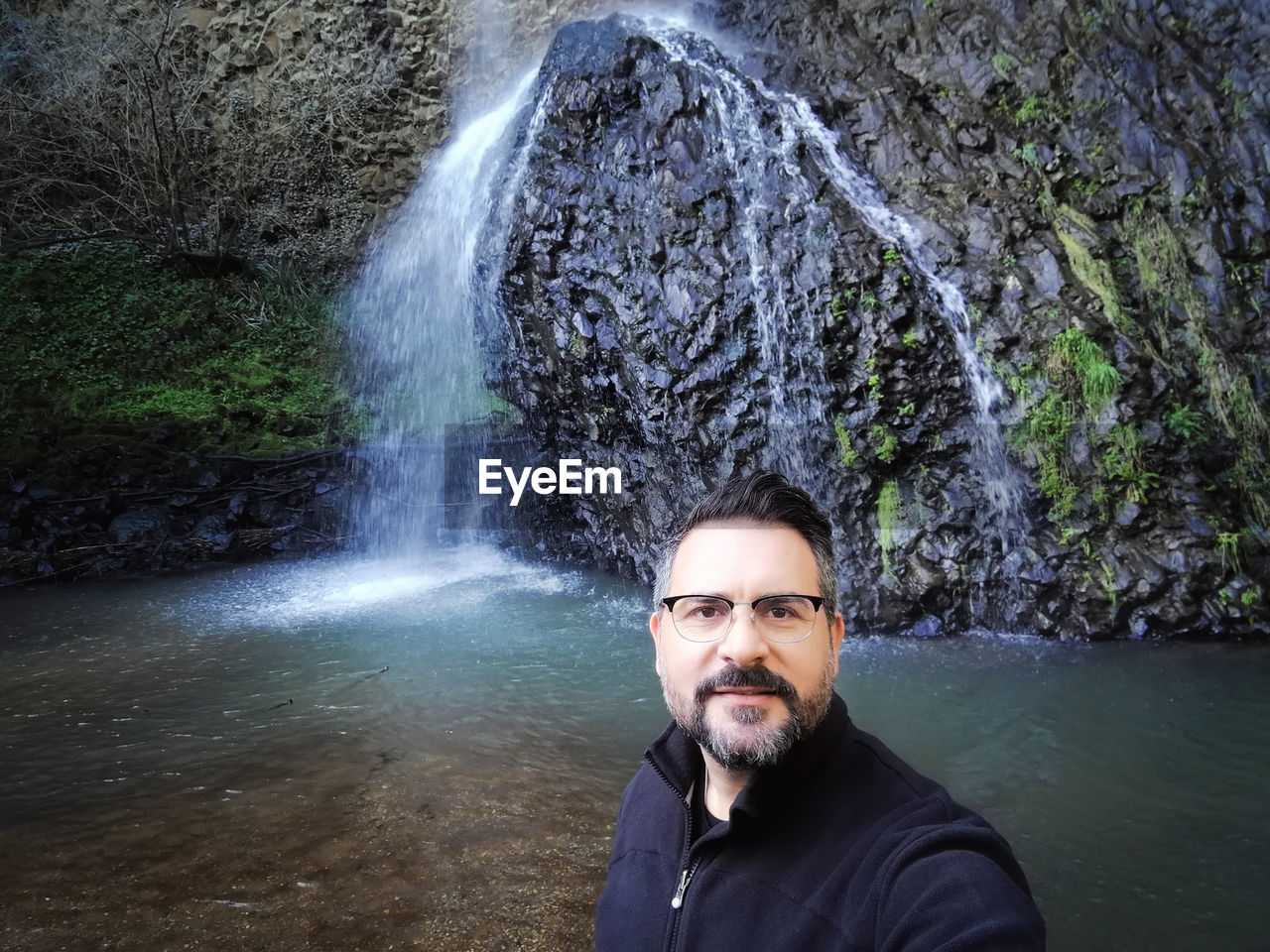 Portrait of man against waterfall