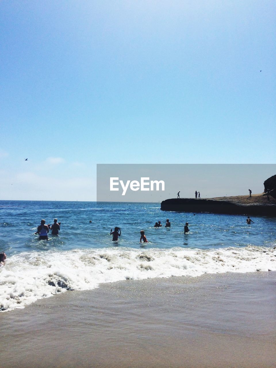 People enjoying on beach on sunny day