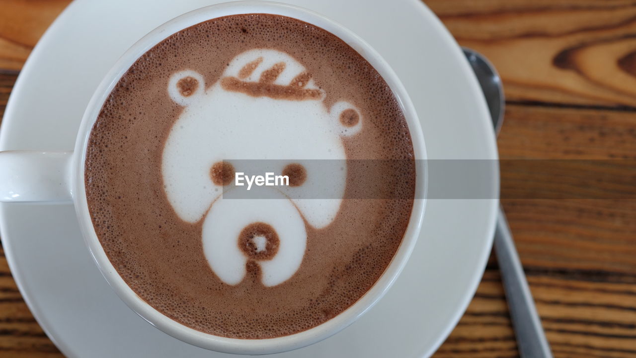 CLOSE-UP OF COFFEE CUP WITH TEXT ON TABLE