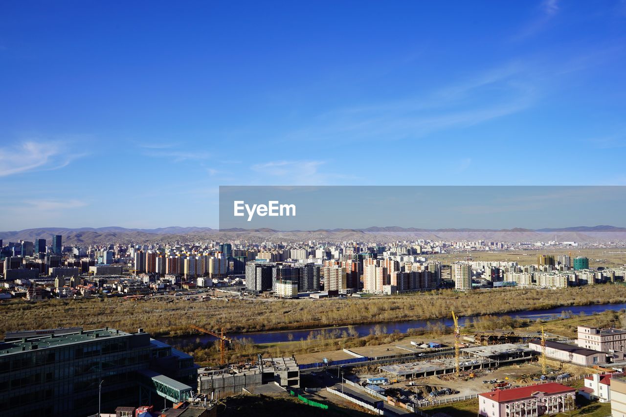 High angle view of buildings against blue sky