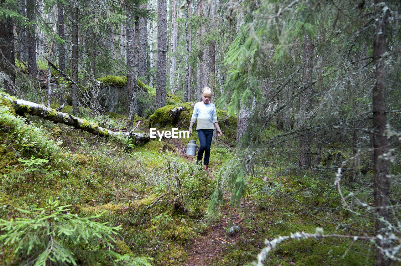 Girl in forest picking mushrooms