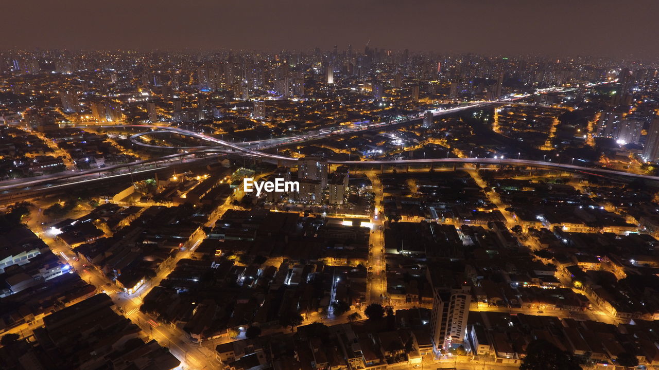 Aerial view of illuminated cityscape against sky at night