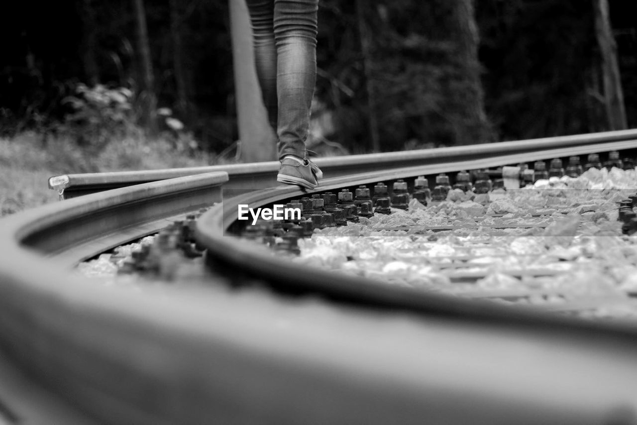 Low section of person walking on railroad tracks