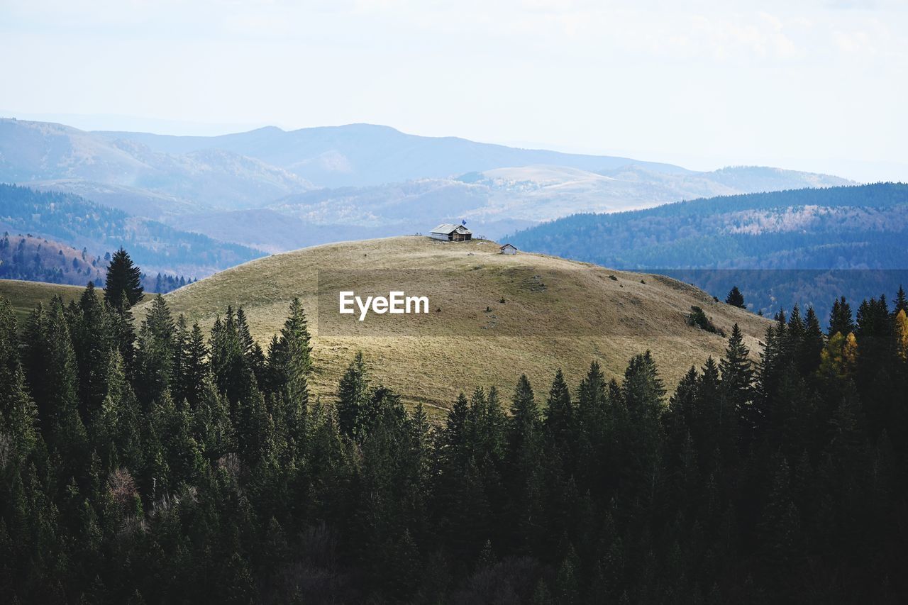 Scenic view of house on top of mountain against sky