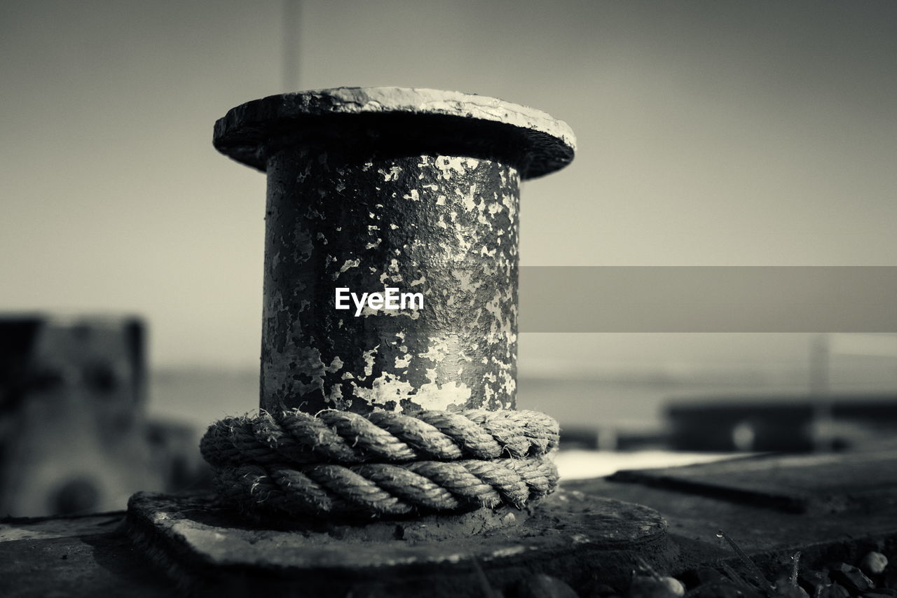 Close-up of rope on weathered boat bollard