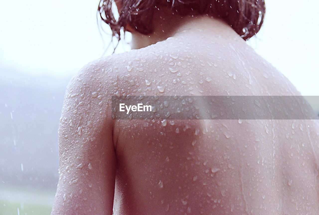 Rear view of shirtless kid back wet skin