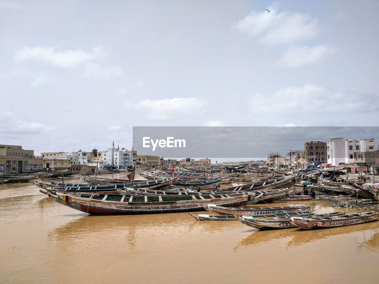 Boats moored in city against sky