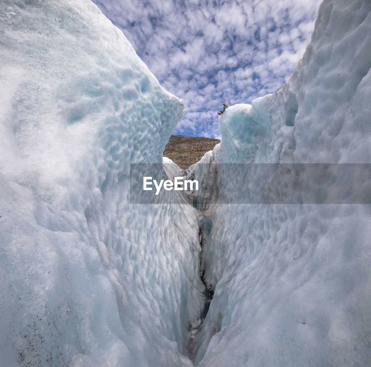 Guide sitting on edge of crevasse