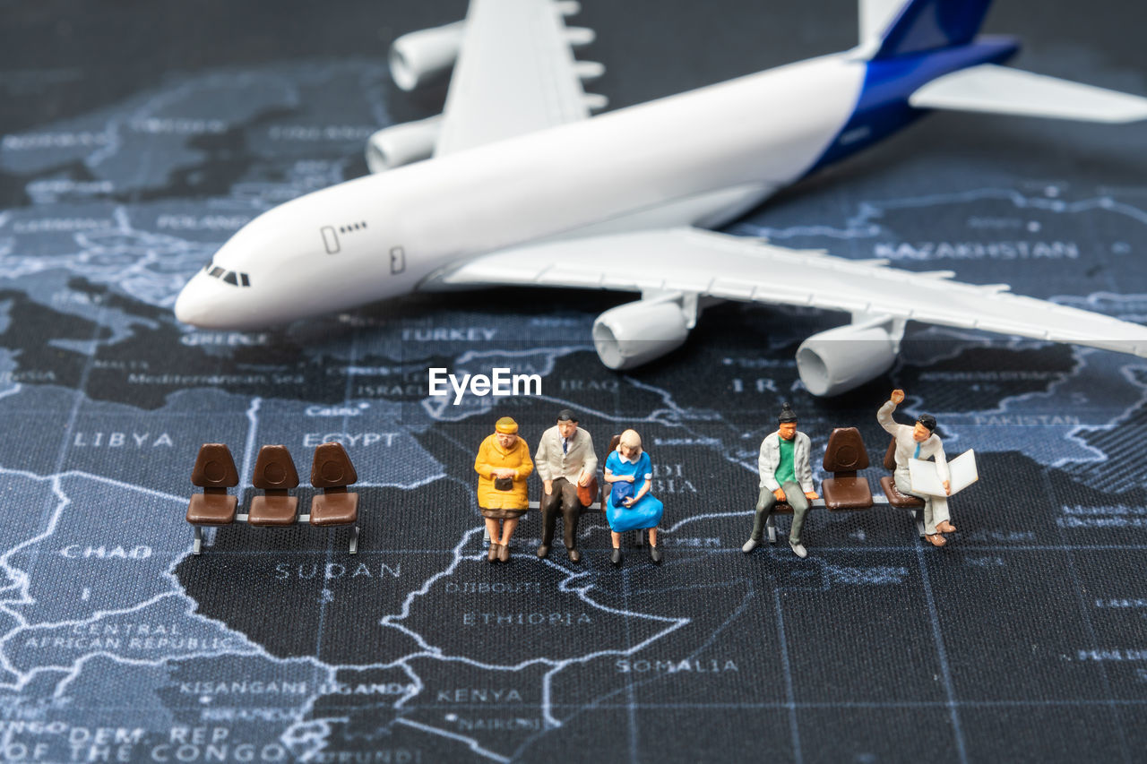 HIGH ANGLE VIEW OF PEOPLE AND TOY ON TABLE AT BUS