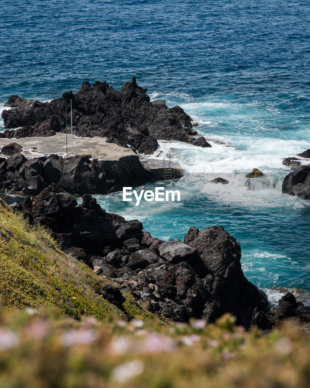 Rocks by sea during sunny day