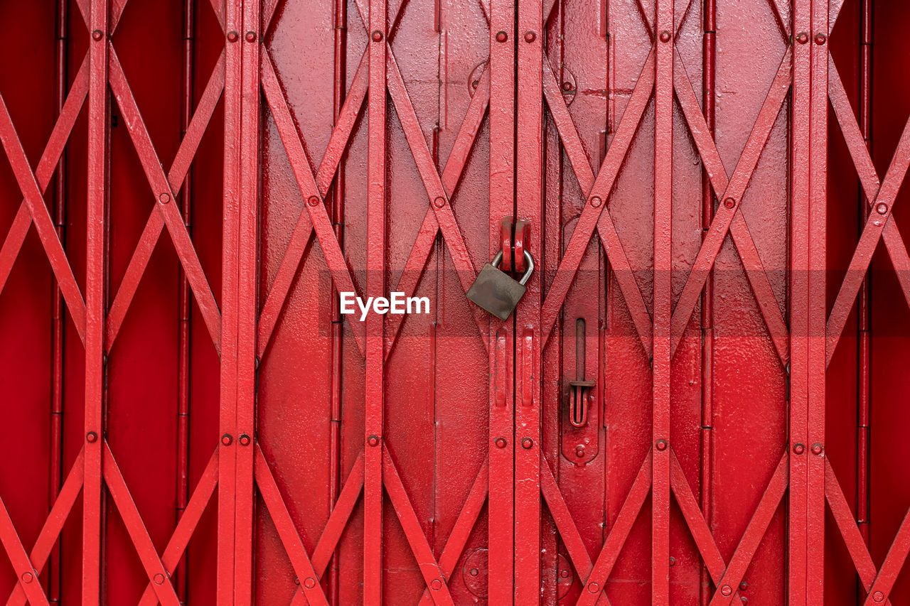 Close-up of padlock on red gate