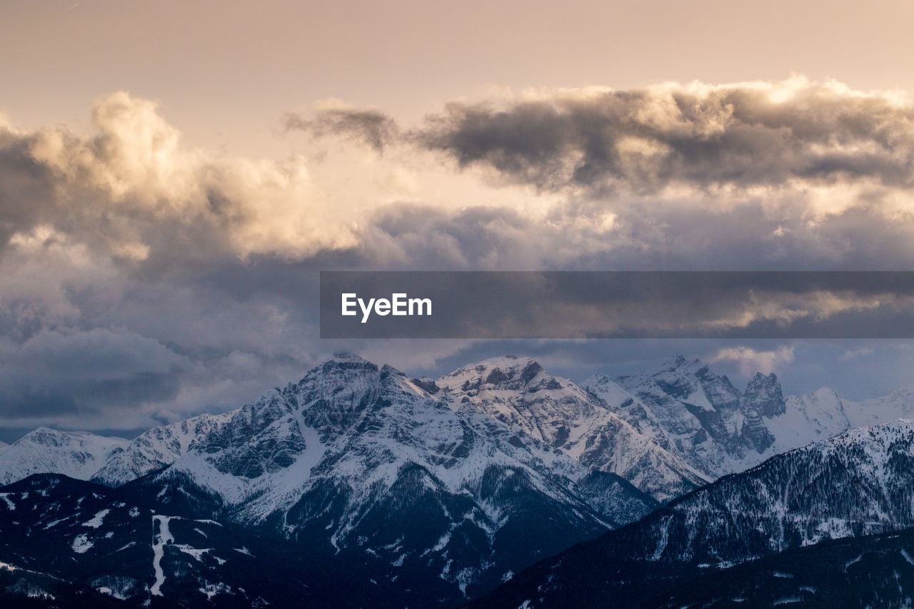 AERIAL VIEW OF SNOWCAPPED MOUNTAINS AGAINST SKY DURING WINTER