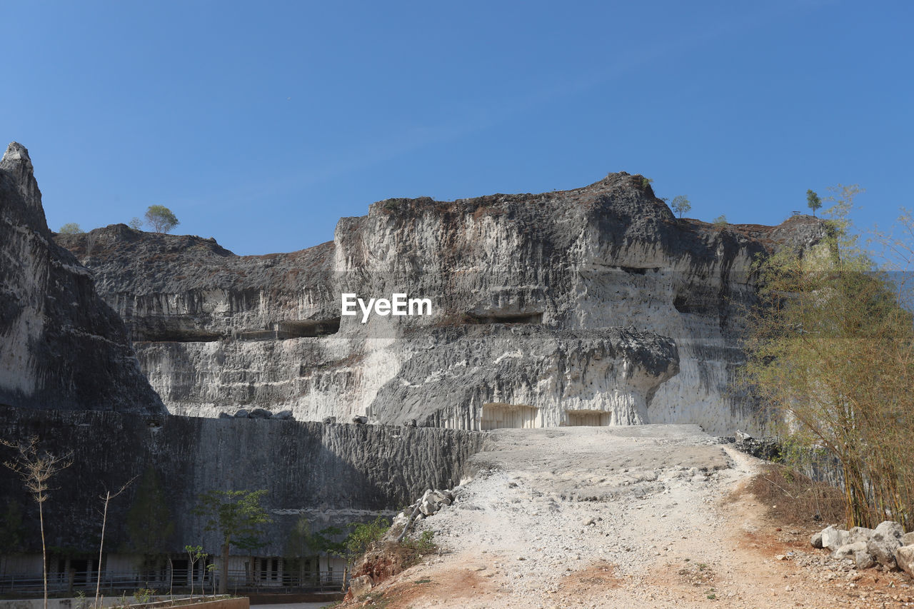 View of rock formations against clear blue sky