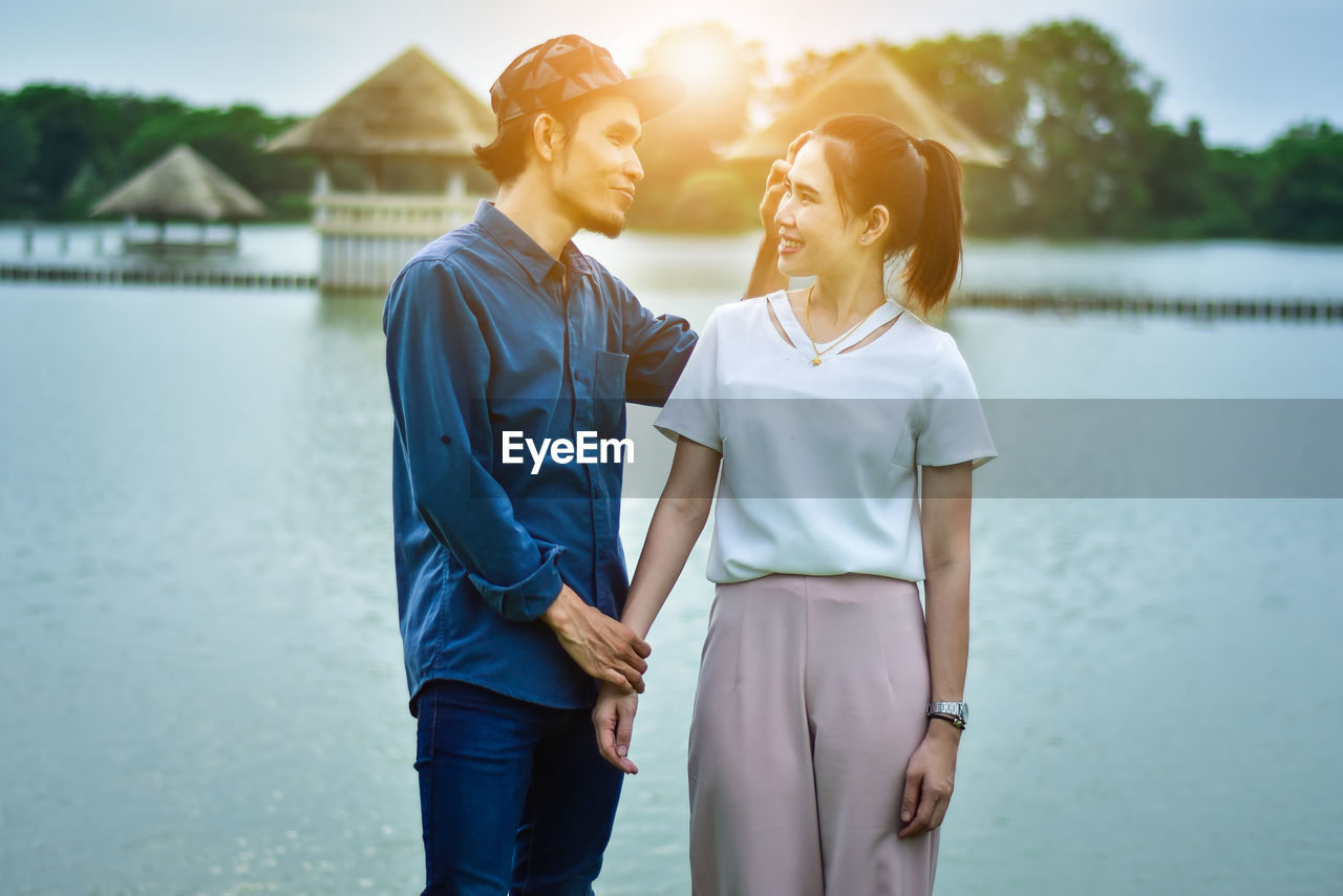 Smiling couple standing by river