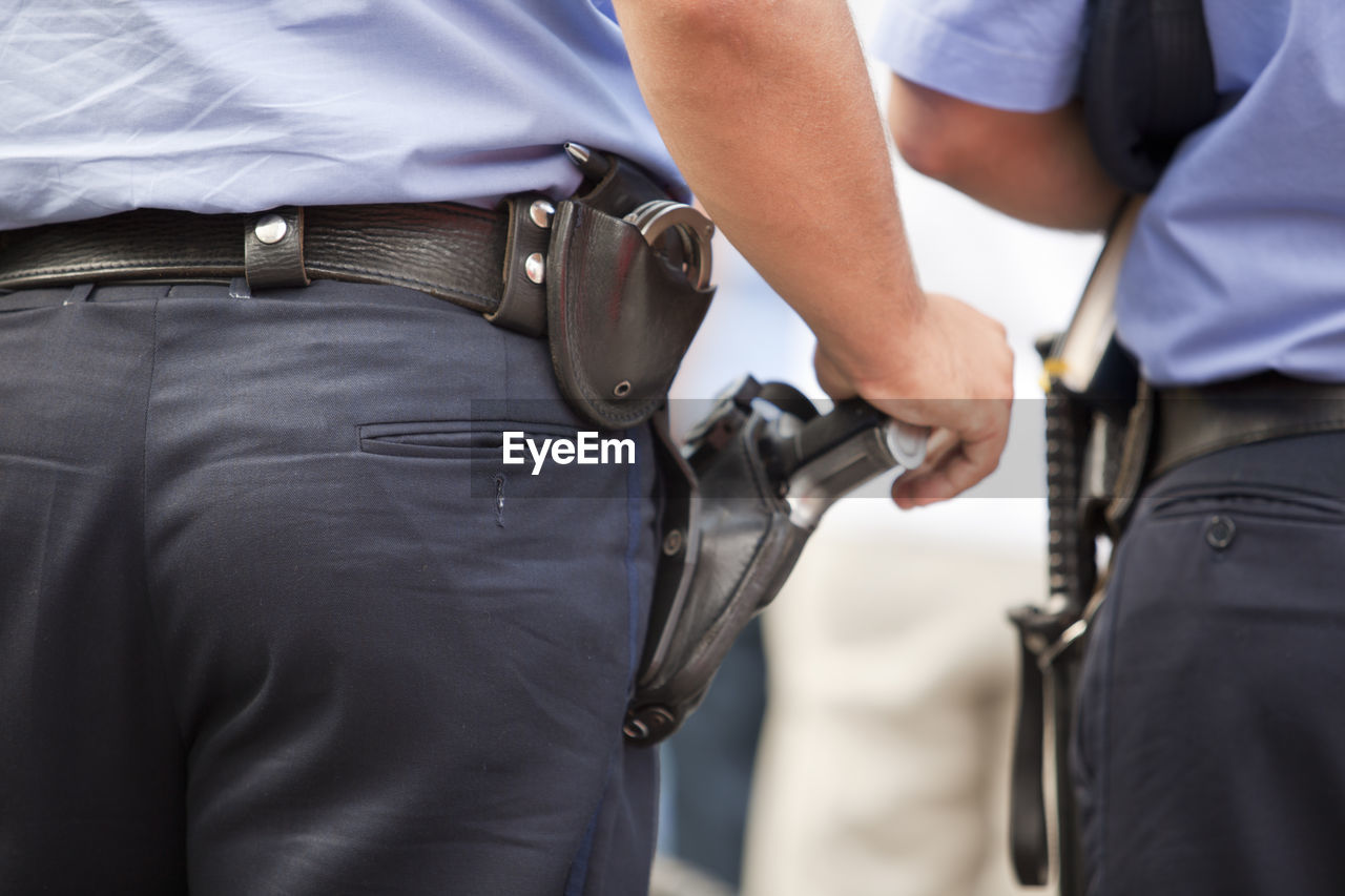 Midsection of security staff with handguns