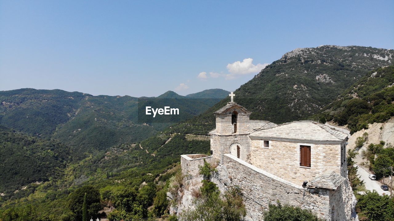 BUILDING BY MOUNTAIN AGAINST SKY