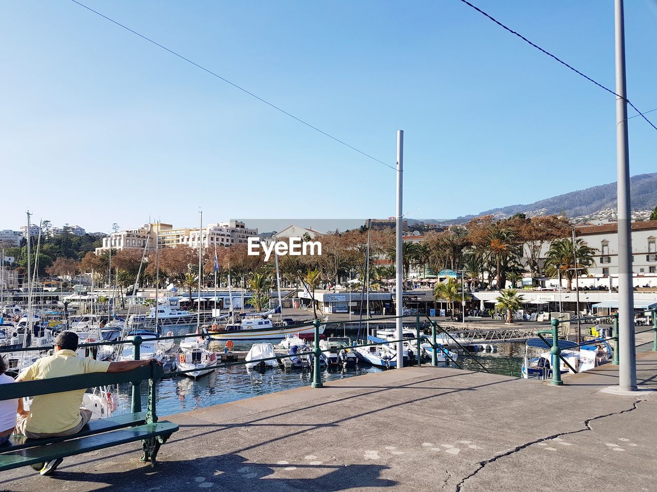 Sailboats on street by buildings against sky