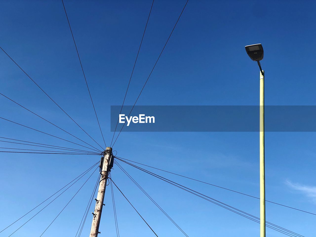 LOW ANGLE VIEW OF ELECTRICITY PYLON AGAINST BLUE SKY