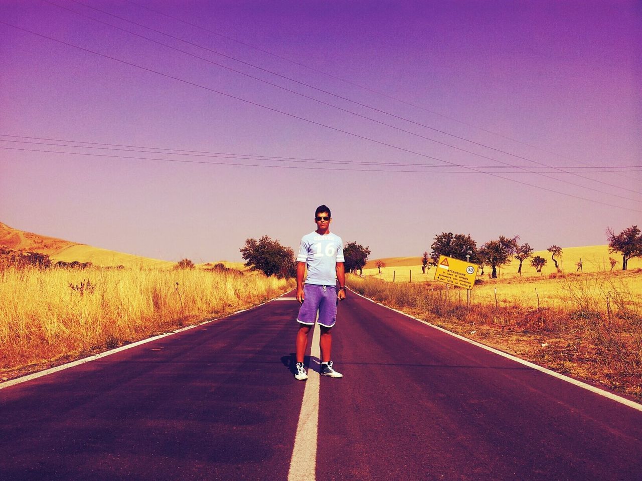 Full length of man standing on road against clear sky