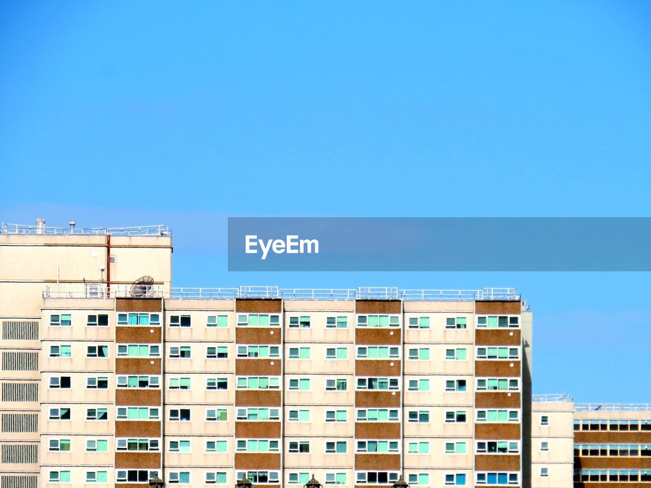 Low angle view of buildings against clear blue sky