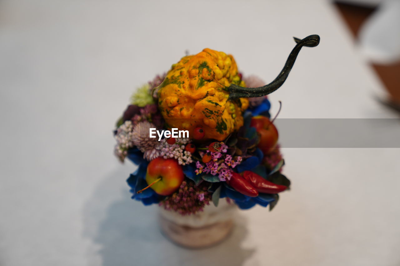 HIGH ANGLE VIEW OF MULTI COLORED FLOWER ON WHITE TABLE