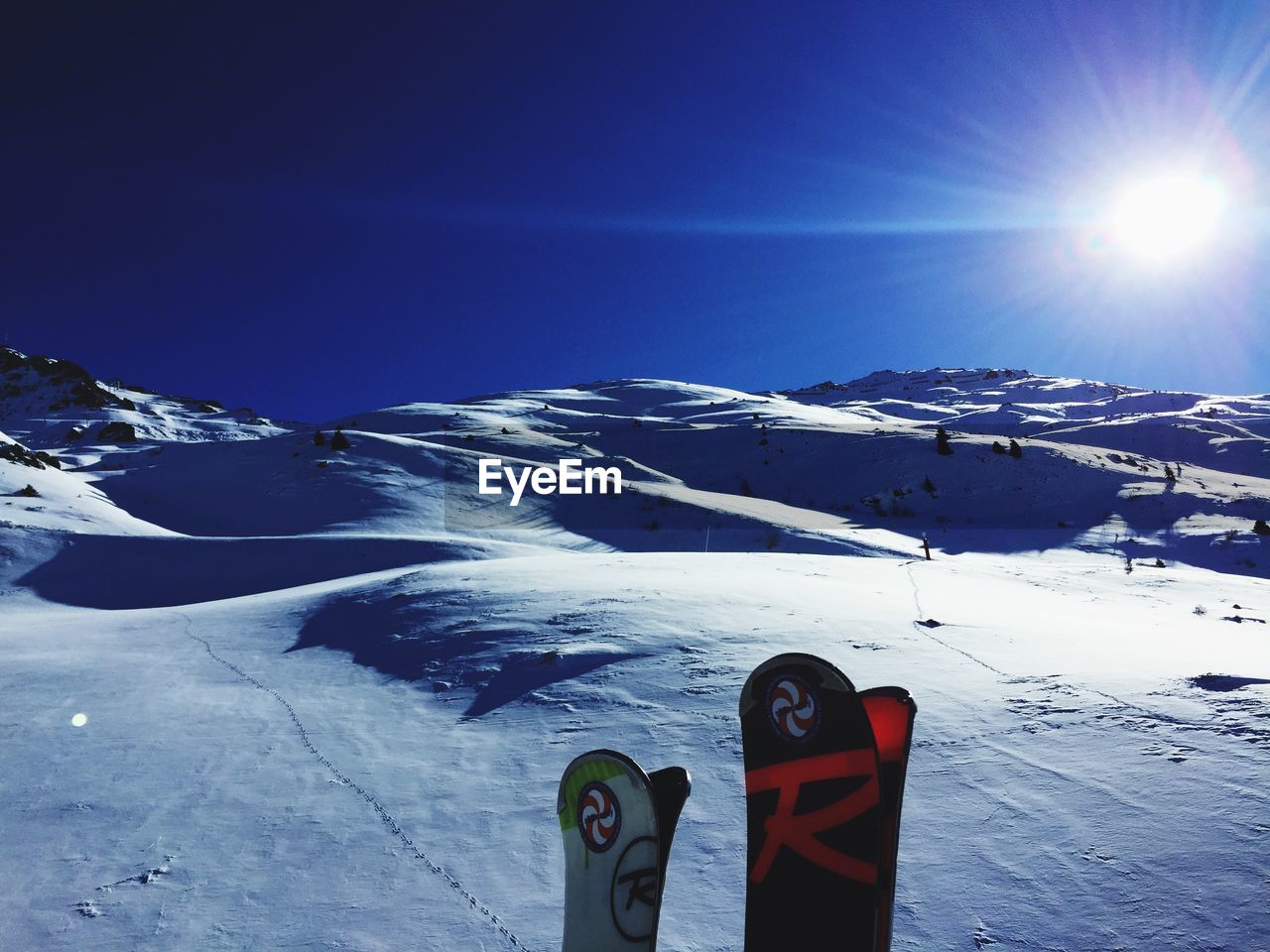 Scenic view of snow covered mountain against blue sky