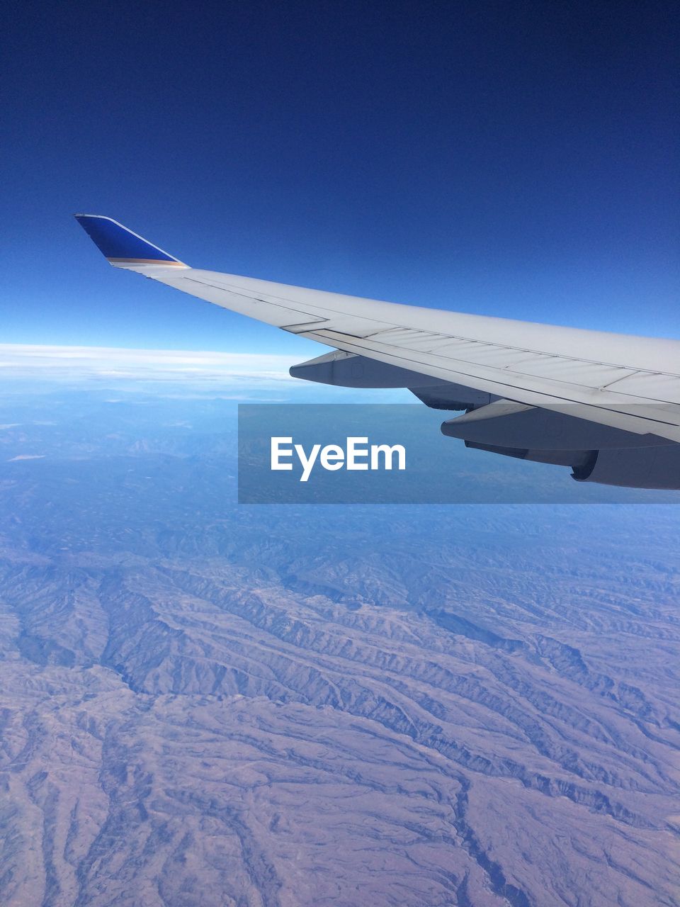 Cropped image of airplane flying above dramatic landscape