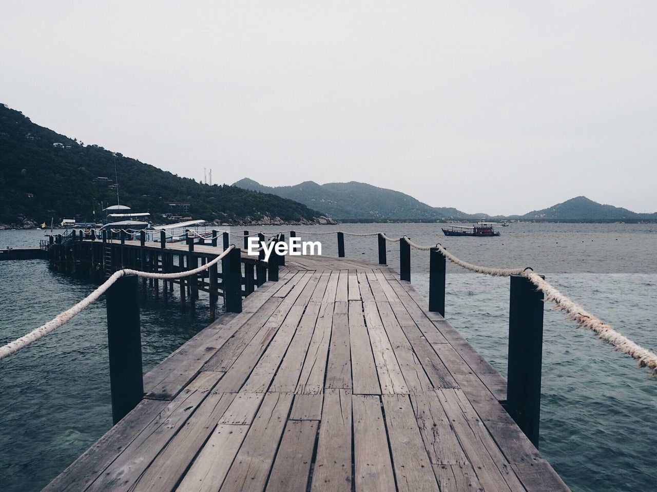 Wooden pier over sea against clear sky