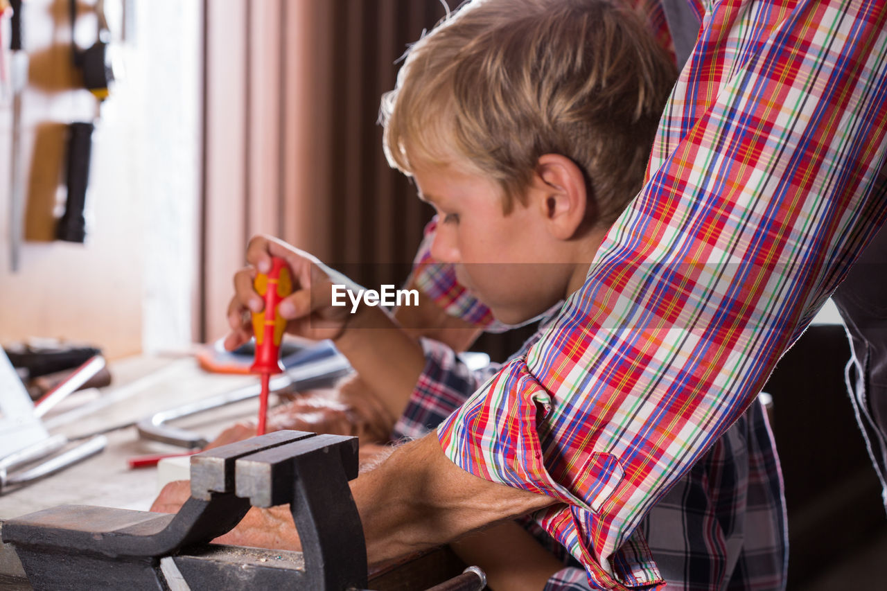 Side view of boy sitting on table