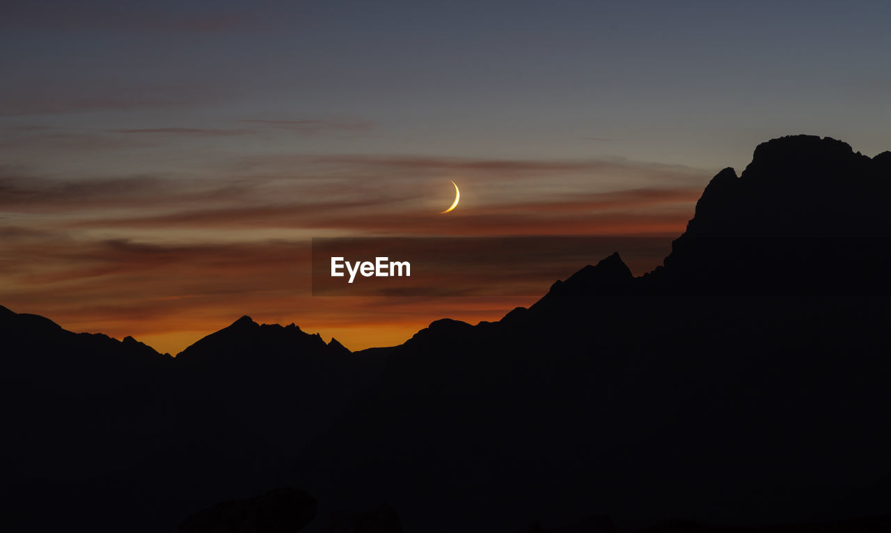 SCENIC VIEW OF SILHOUETTE MOUNTAINS AGAINST SKY AT NIGHT